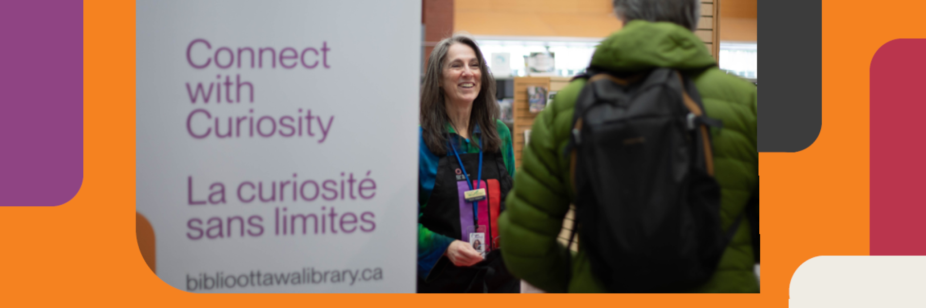 Librarian and client chatting as they stand beside a new branded rollup