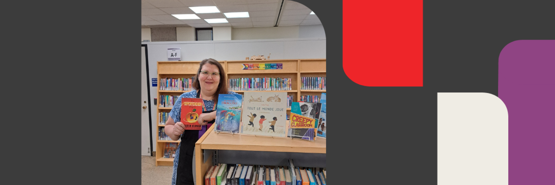 Librarian standing near bookshelf holding a children's book