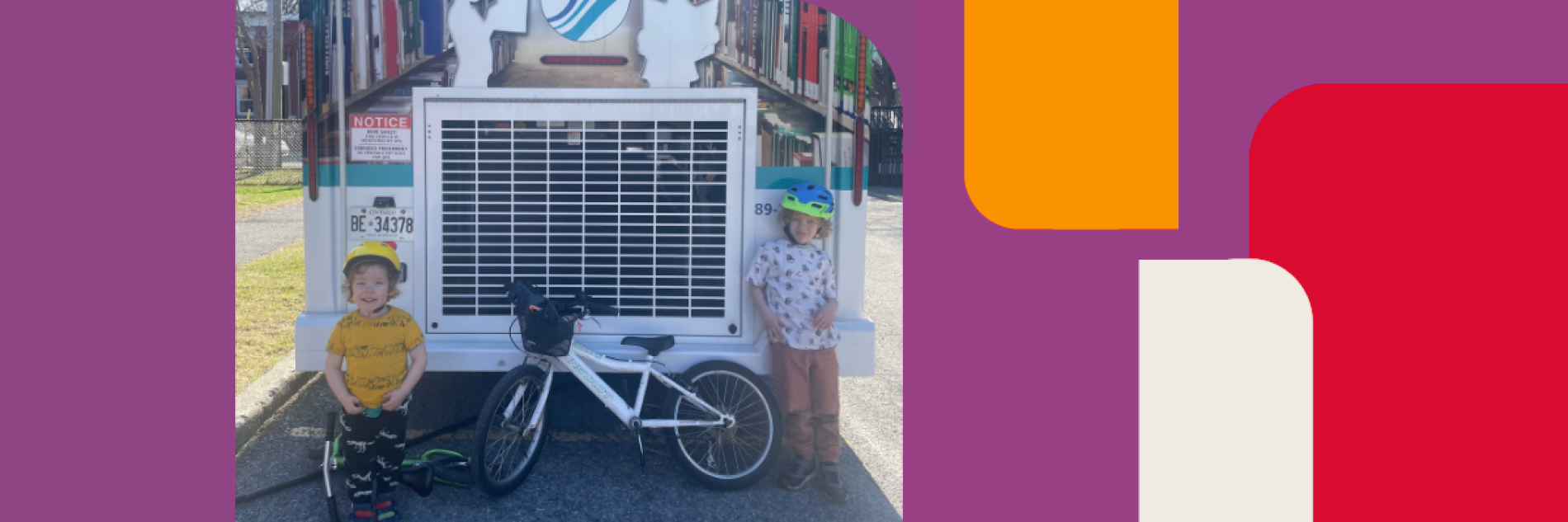 Two kids standing in front of the Bookmobile | Deux enfants devant le Bibliobus