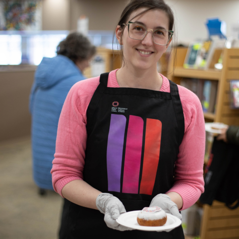 Library staff holding a plate with a new branded donut