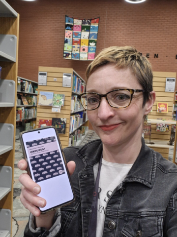 Photo of Vero Dupuis showing the cover of Ordures ! Journal d'un vidangeur by Simon Paré-Poupart on her phone